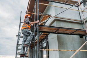 Builder climbing on scaffolding