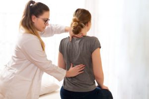 Physiotherapist examining patients back