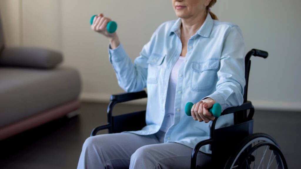 woman in a wheelchair lifting dumbbells