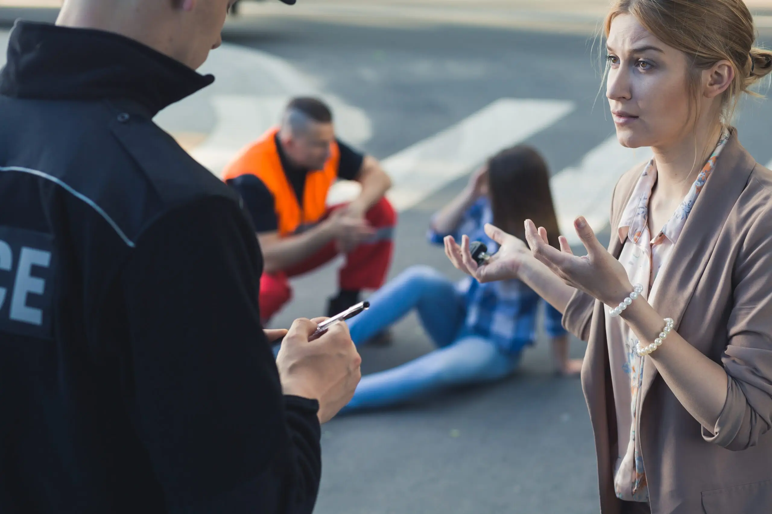 Woman talking with the police officer after a car accident
